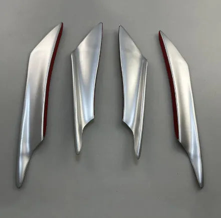 Set of four black ABS plastic bumper blade spoilers for car modification on a white background.