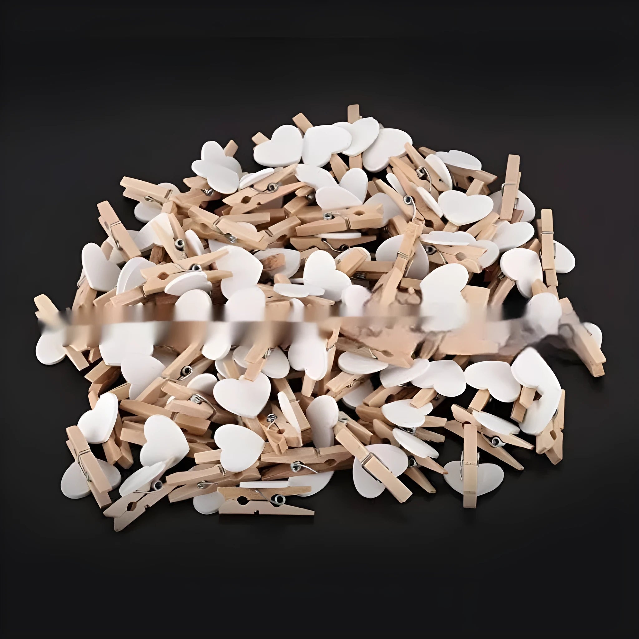 Five small handmade solid wood heart-shaped clips in assorted colours on a white surface.