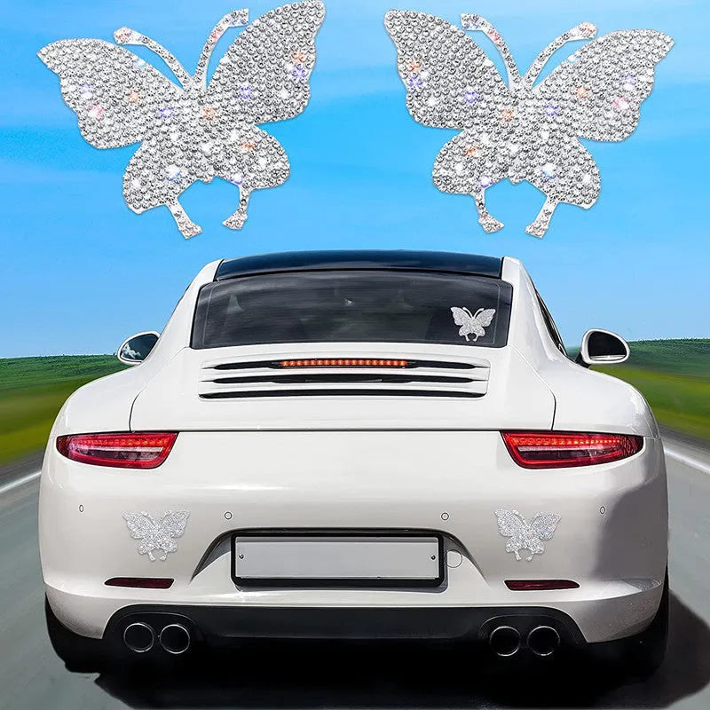 Close-up of a diamond-encrusted glass car sticker in a butterfly or bear claw design on a white background.