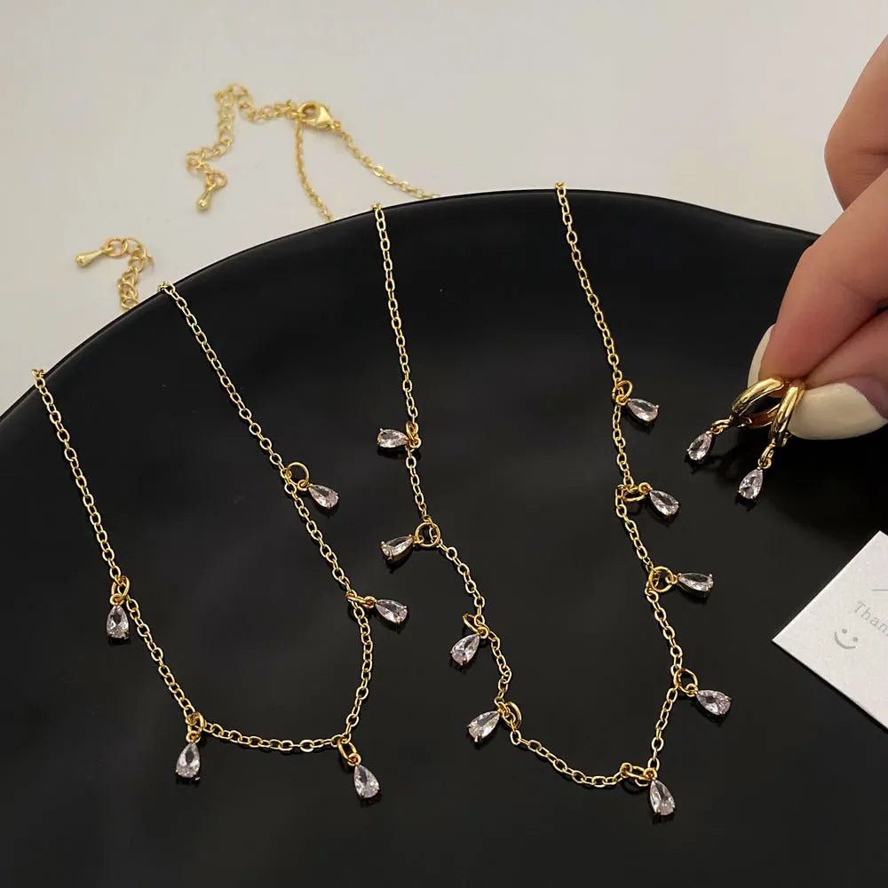 Women's zircon jewellery set with geometric meteor shower necklace, matching earrings, and anklet.