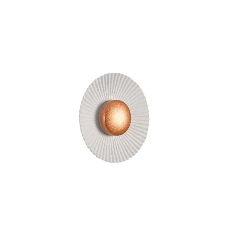 Round aluminium wall lamp with outer white and inner gold finish mounted on a wall