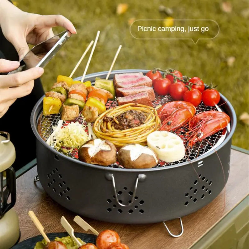 Portable stainless steel charcoal barbecue grill with detachable parts and a carry bag.