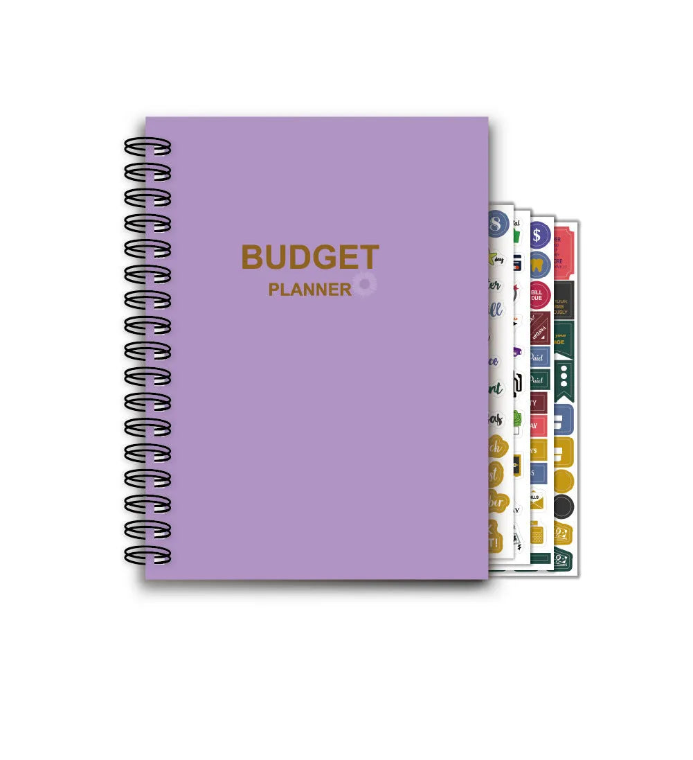 Purple coil-bound budget notebook open showing monthly planning pages with financial stickers and paper clips