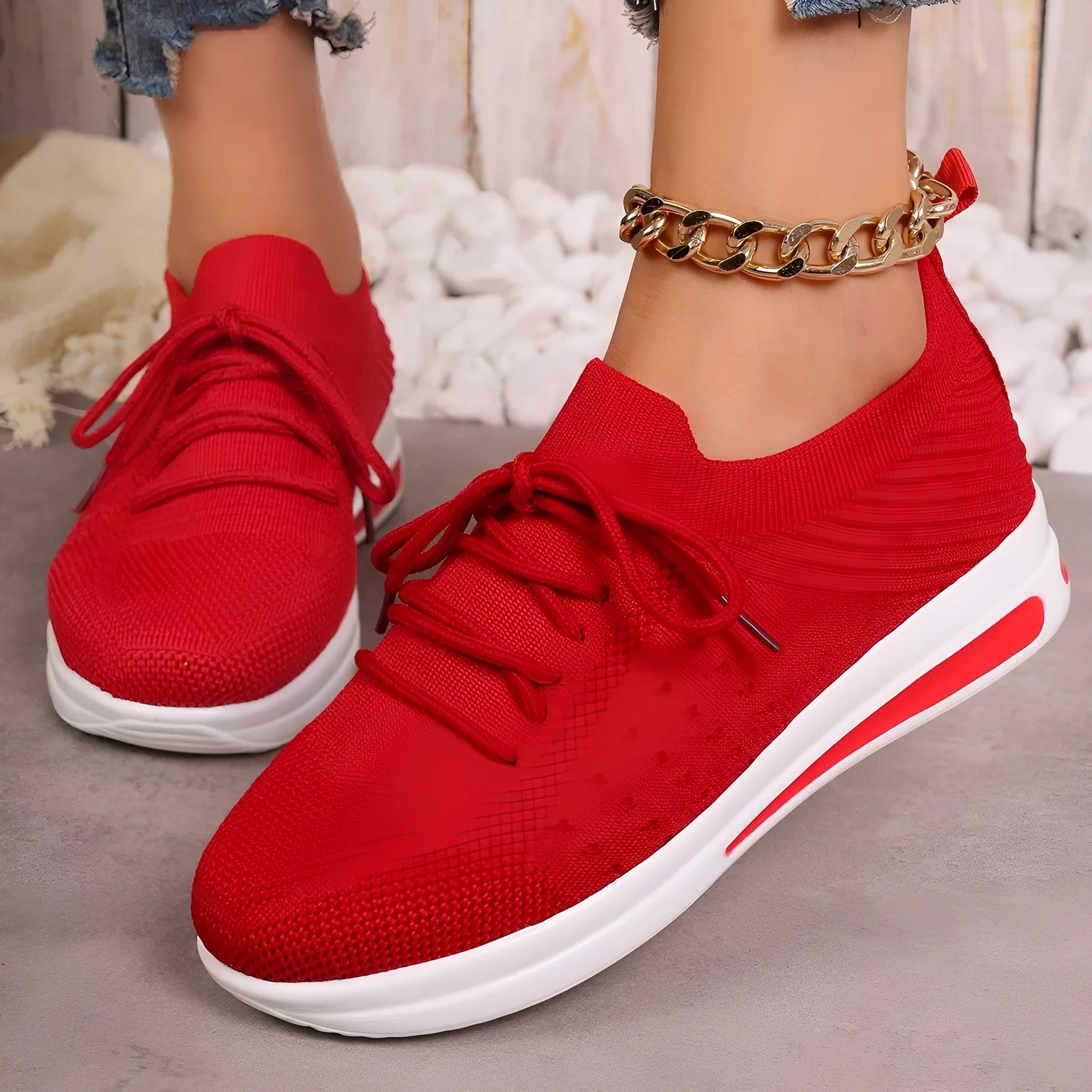 Women's low-top fly-knit sneakers in black, blue, or red with round toe and lace-up front.