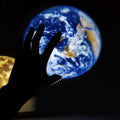 Earth and moon projection lamp with adjustable hose bracket on wooden surface