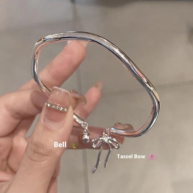 Silver adjustable bracelet with bow charm and sliding clasp mechanism