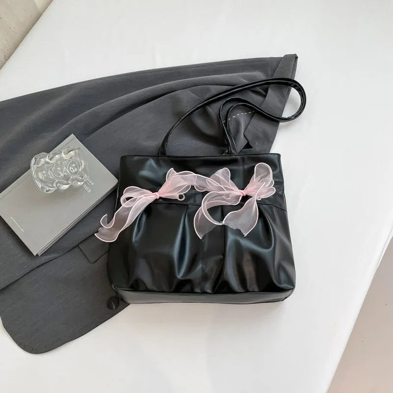 Black college-style bow tote bag with double shoulder straps and zippered compartment