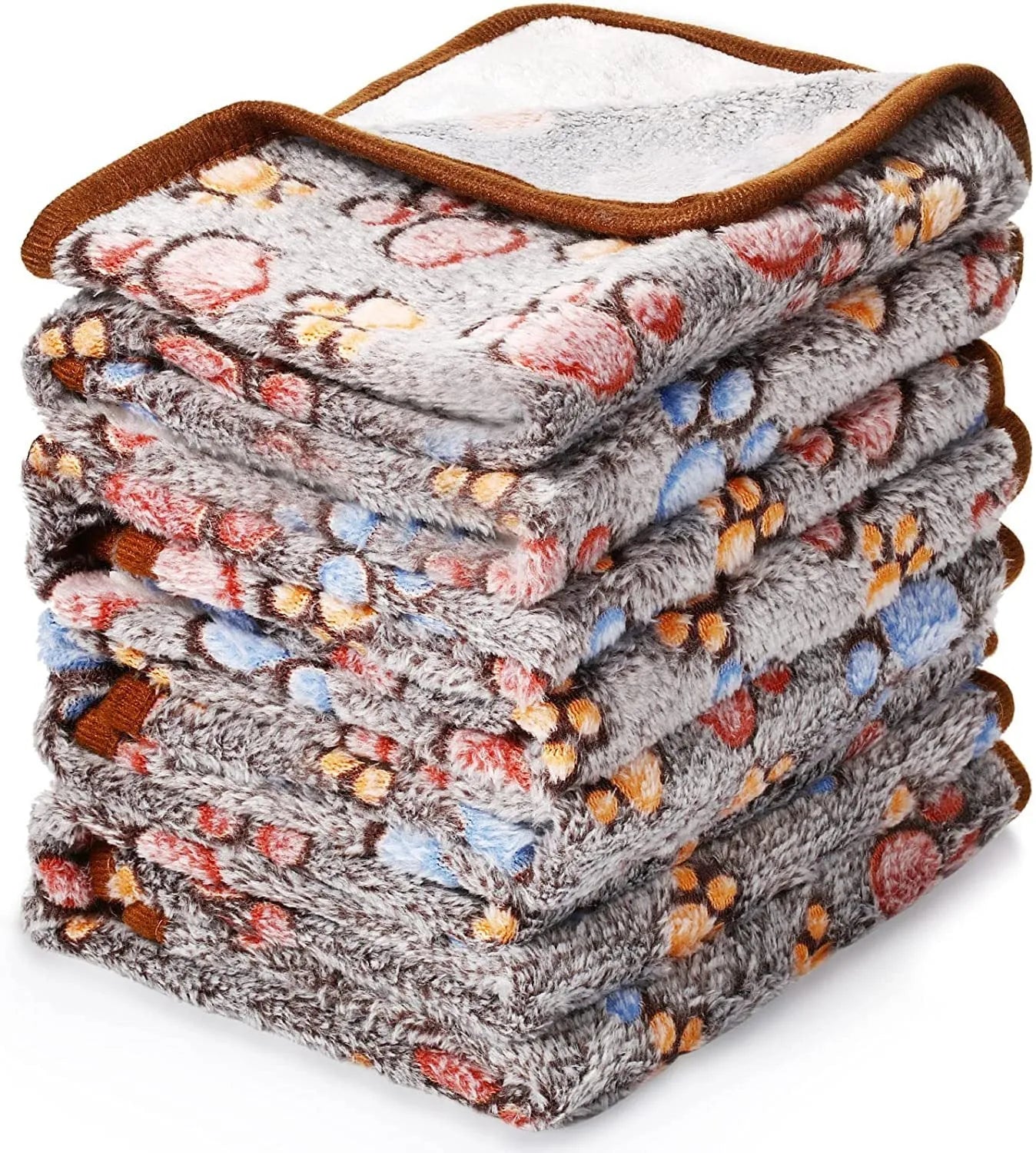 Coral fleece dog blanket with paw print pattern in beige, shown in a large size on a dog bed.