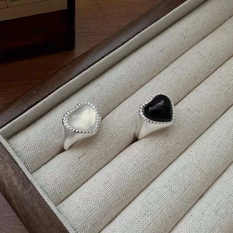 Adjustable open mouth sterling silver ring with a black agate heart on a silver band.