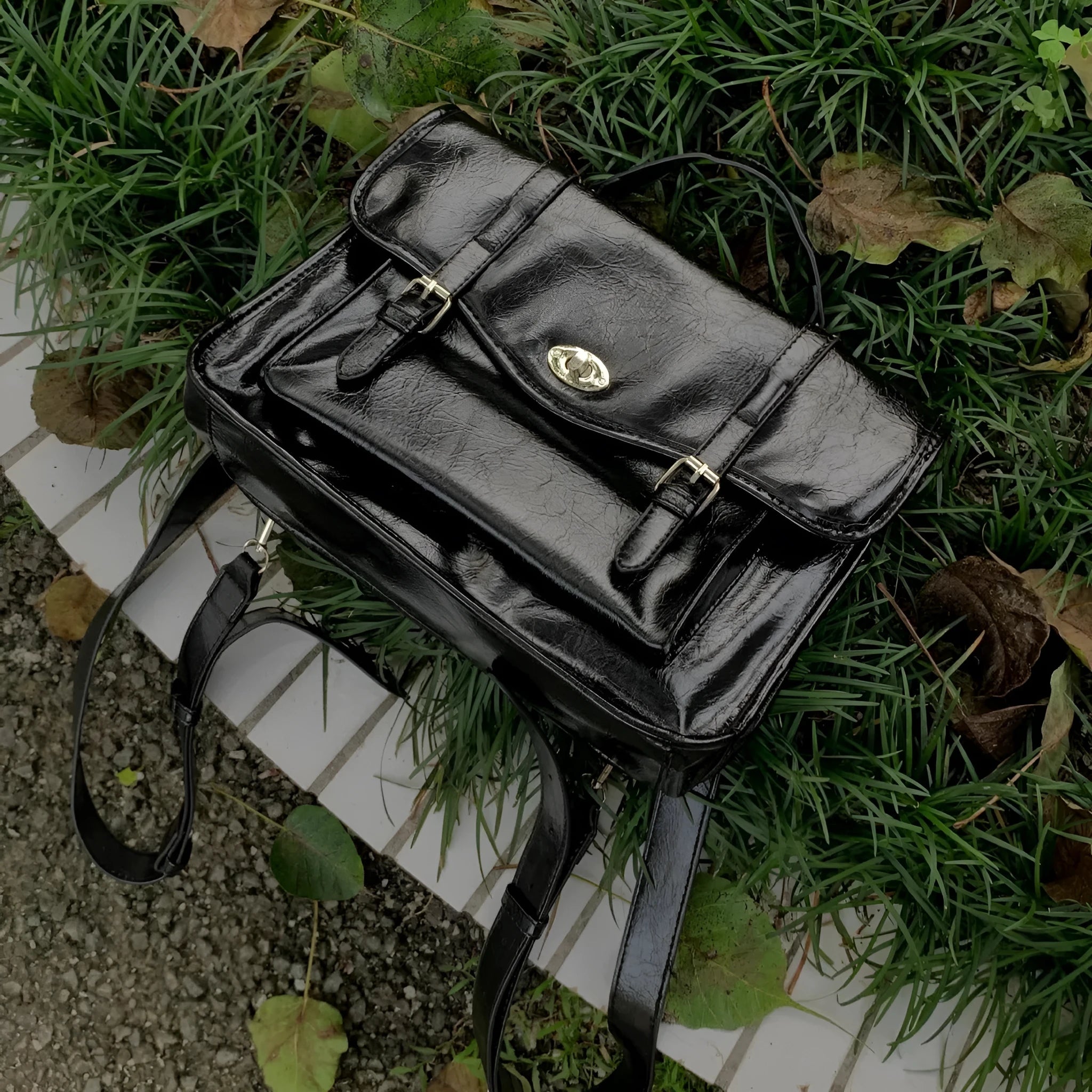Black college messenger bag with oil wax leather texture showing front compartment and cross-body strap