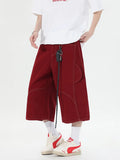 Red retro denim shorts with wide leg and multiple pockets laid flat.
