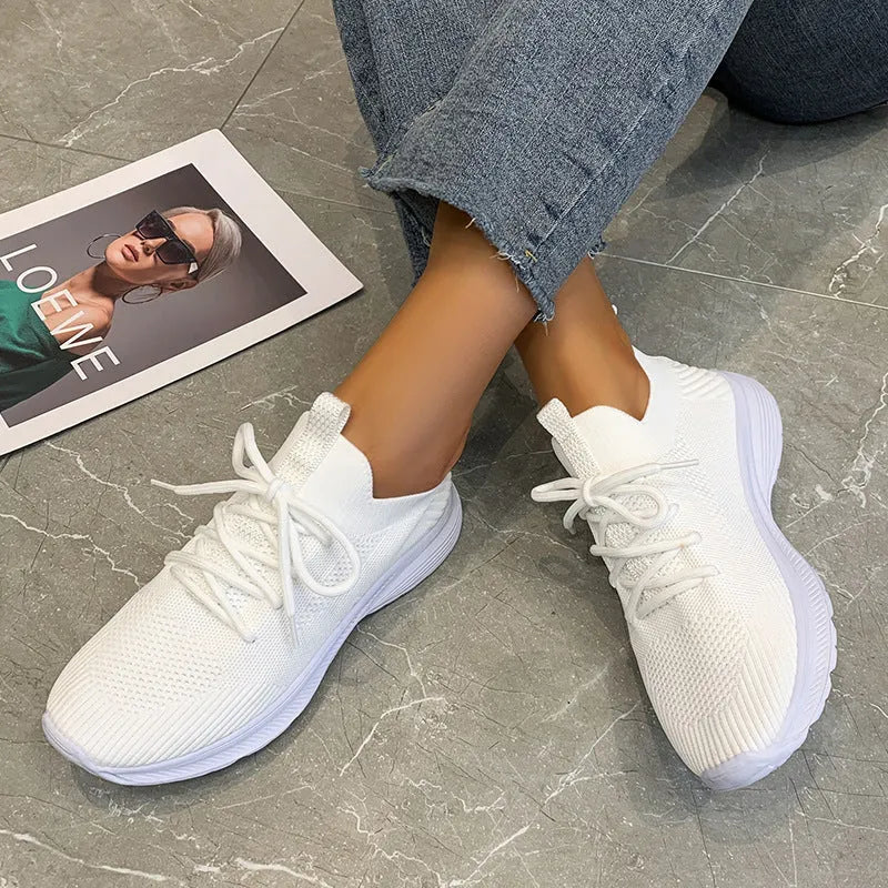 Women's mesh running shoes in creamy white with Flyknit upper and flat rubber sole
