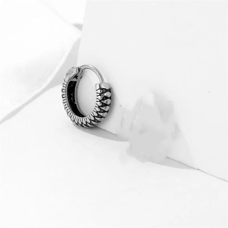 Silver geometric earrings with retro twist design and striped detailing on circular stainless steel form