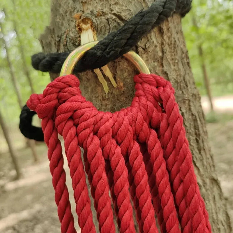 Outdoor nylon rope mesh hammock hanging between two trees, showing its woven construction and spacious 1.1m by 2.1m size.