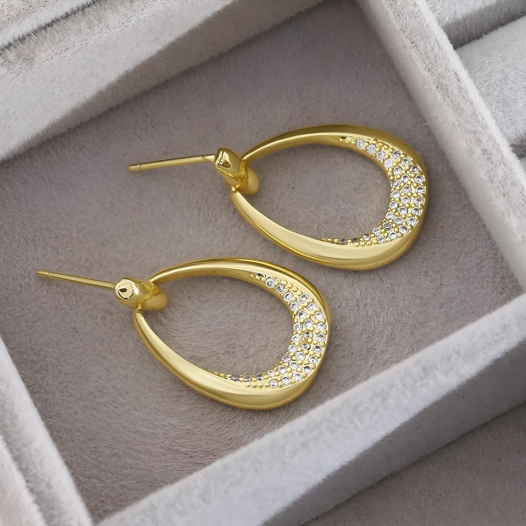 Yellow gold geometric drop earrings for women with round and oval elements, shown with handbag packaging.