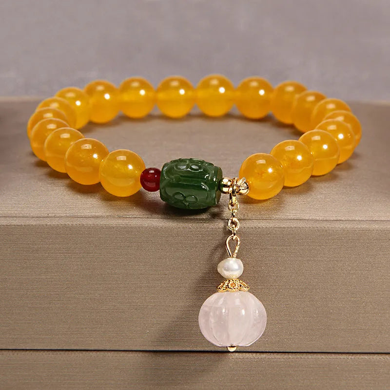 Yellow agate crystal bracelet with gold silk cord and adjustable sliding knot on a wrist.