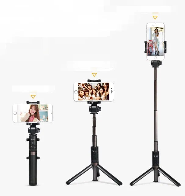 Black Bluetooth selfie stick tripod with remote control extended next to mobile phone
