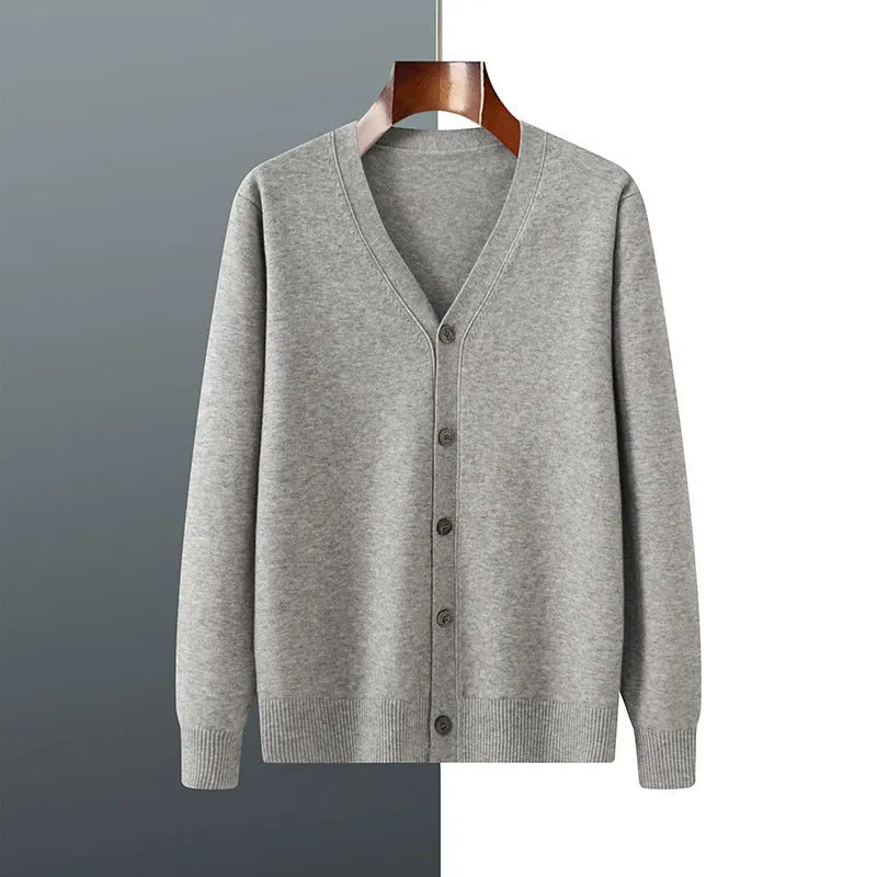 Man wearing a beige V-neck Andy velvet knitted cardigan coat with long sleeves and a loose fit.