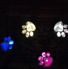Black solar powered bear paw print garden lights set with four lights and solar panel