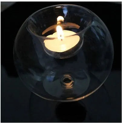 Handmade clear round hollow glass candle holder in three size options on wooden table