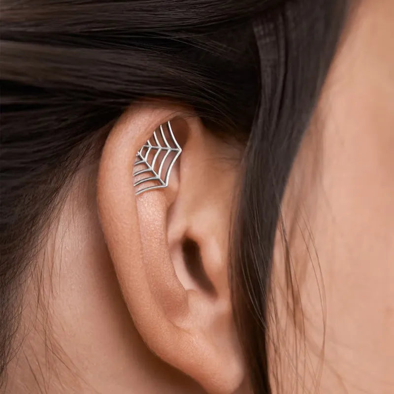 A pair of geometric spider web design stud earrings in an electroplated gold finish.