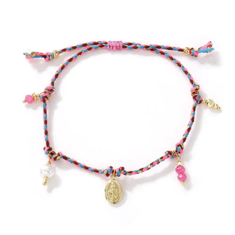 Close-up of a woman's hand-woven colourful braided rope bracelet with an adjustable strap tag.
