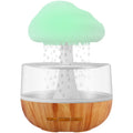 White raining cloud humidifier with night light and essential oil diffuser on table