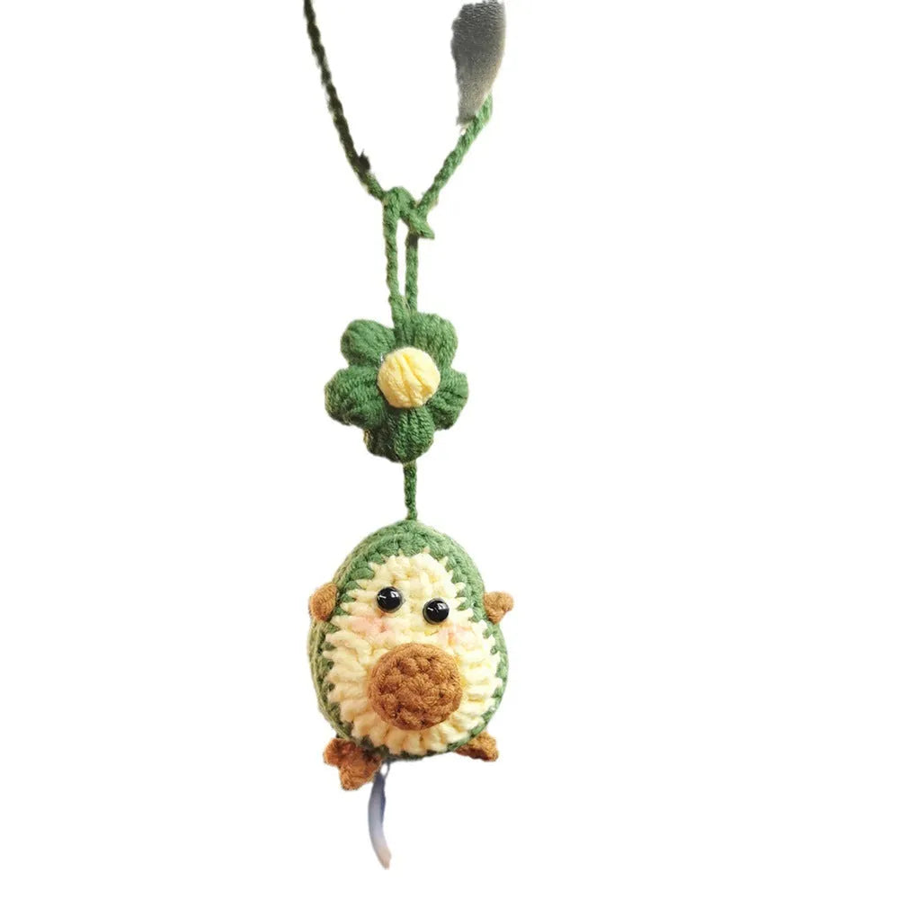 Handmade crocheted car pendant with avocado and rainbow colours hanging from rear-view mirror