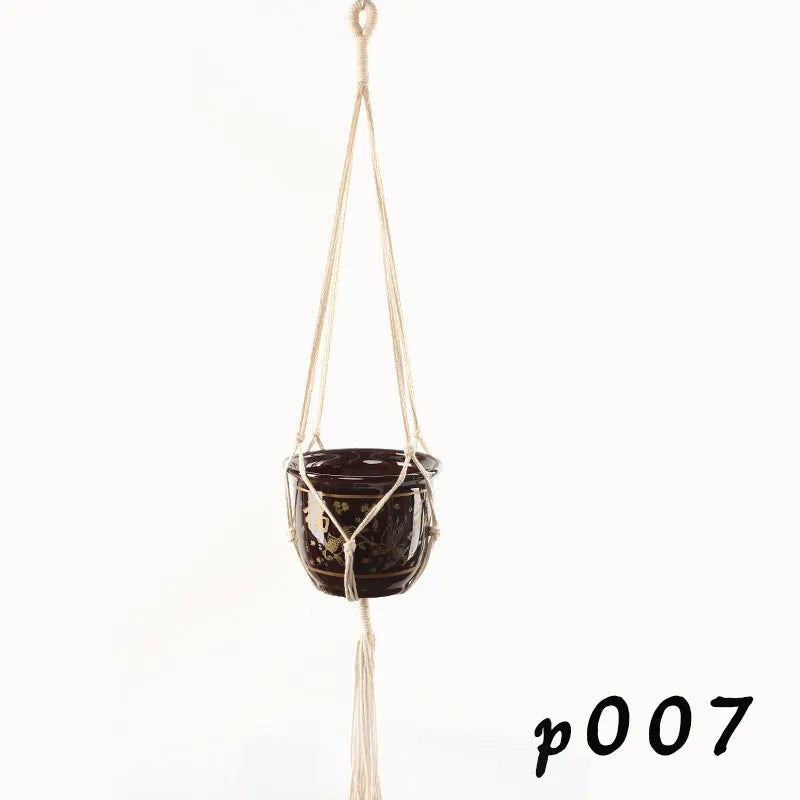Woven cotton rope plant holder in a desktop style with greenery inside.