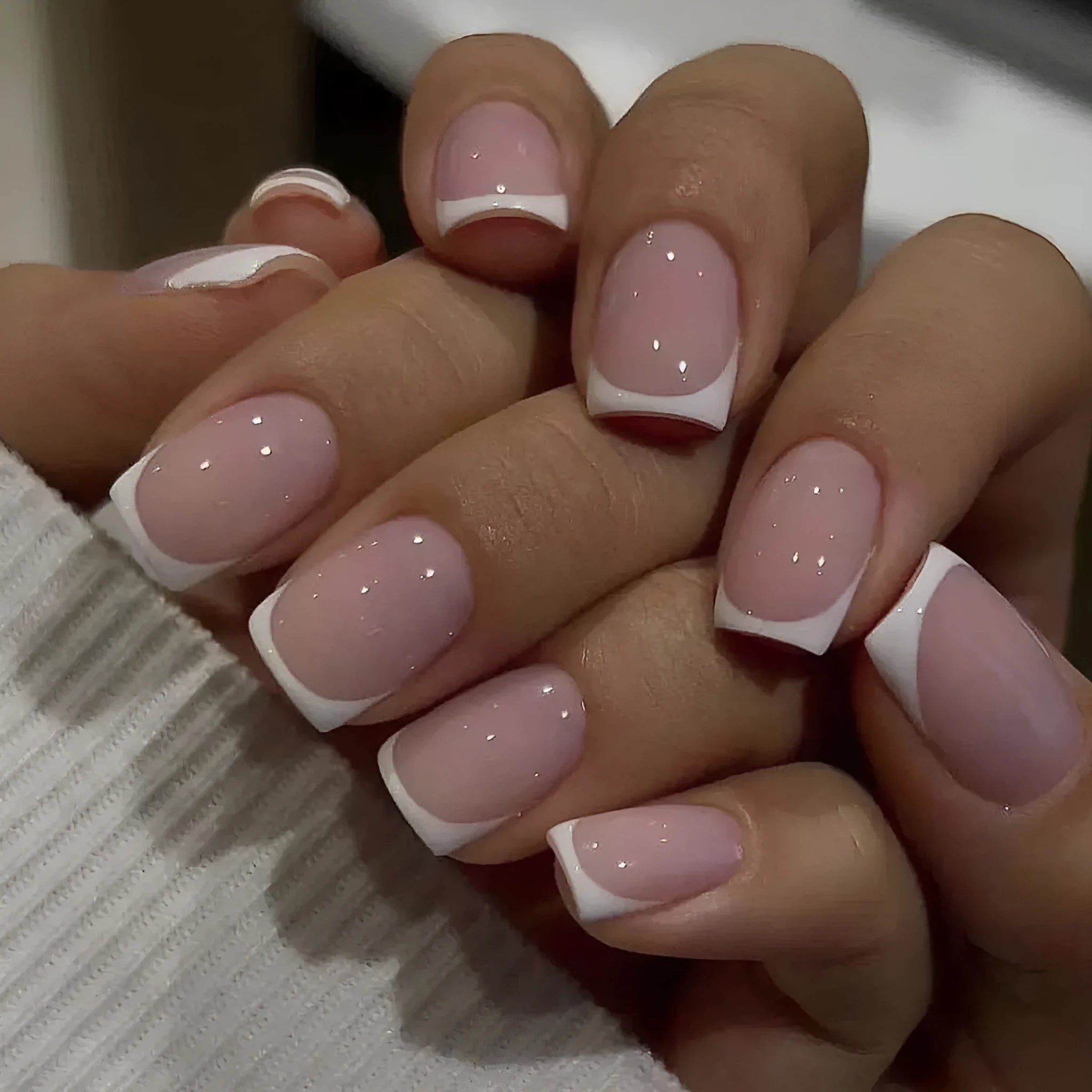 24 white false nail tips with a plaid pattern, laid out on a surface