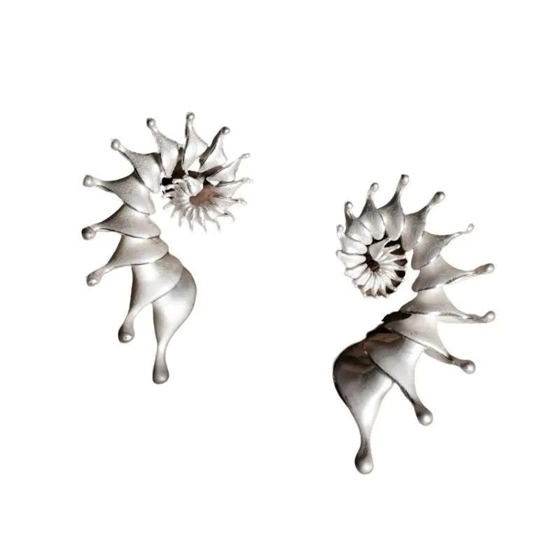 A pair of matte conch-coloured alloy stud earrings with an exaggerated three-dimensional shape.