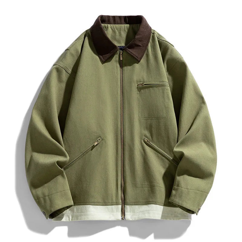 Man wearing a mint green loose-fit retro workwear jacket with contrast lapels and side pockets.
