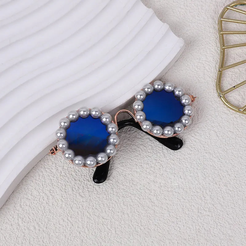 Pearl-rimmed round sunglasses for a cat or dog on a festive background.