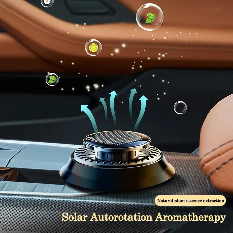 Solar-powered kinetic car air freshener with rotating double rings on car dashboard