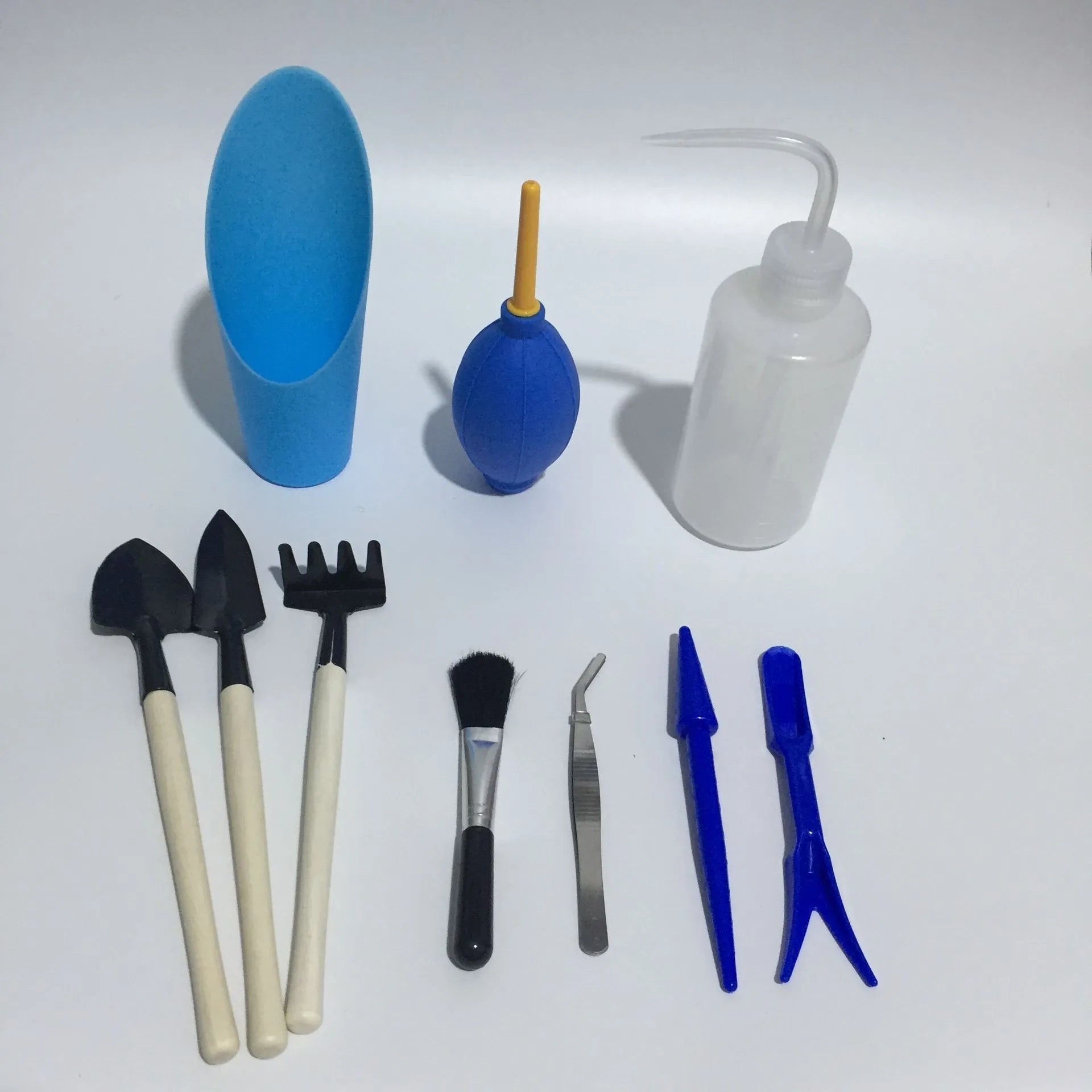 14-piece plastic succulent gardening tool set showing drip kettle, mini shovels, tweezers, and brush on a table.