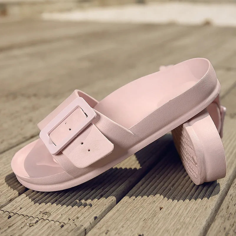 Women's grey blue EVA buckle slippers on a light background, showing the adjustable strap and textured sole.
