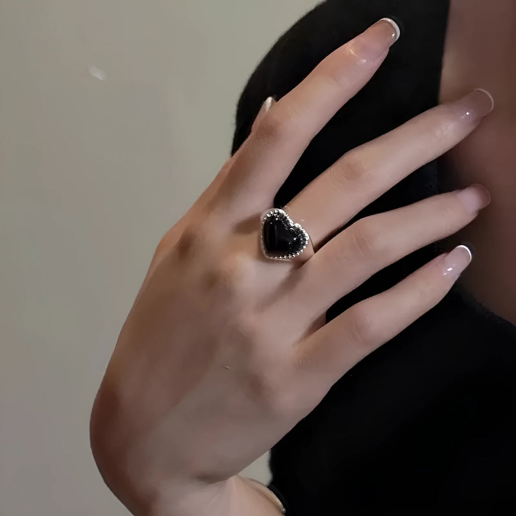 Adjustable open mouth sterling silver ring with a black agate heart on a silver band.