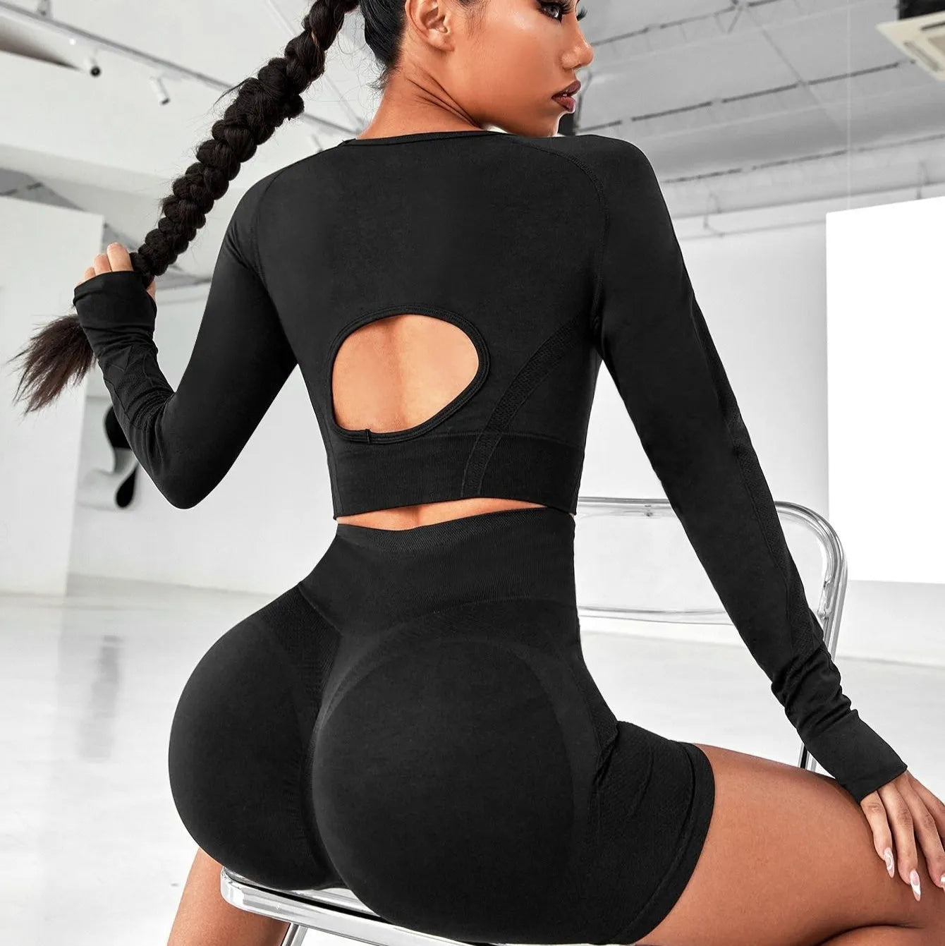 Women's black high waist yoga suit with long sleeve top and tight-fitting trousers on a mannequin.