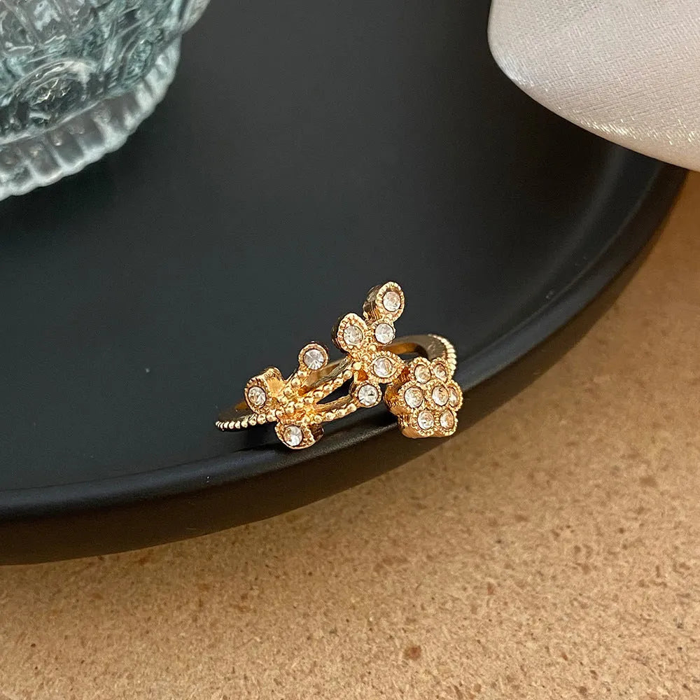 Women's open copper ring with diamond-treated floral and leaf design in gold colour.