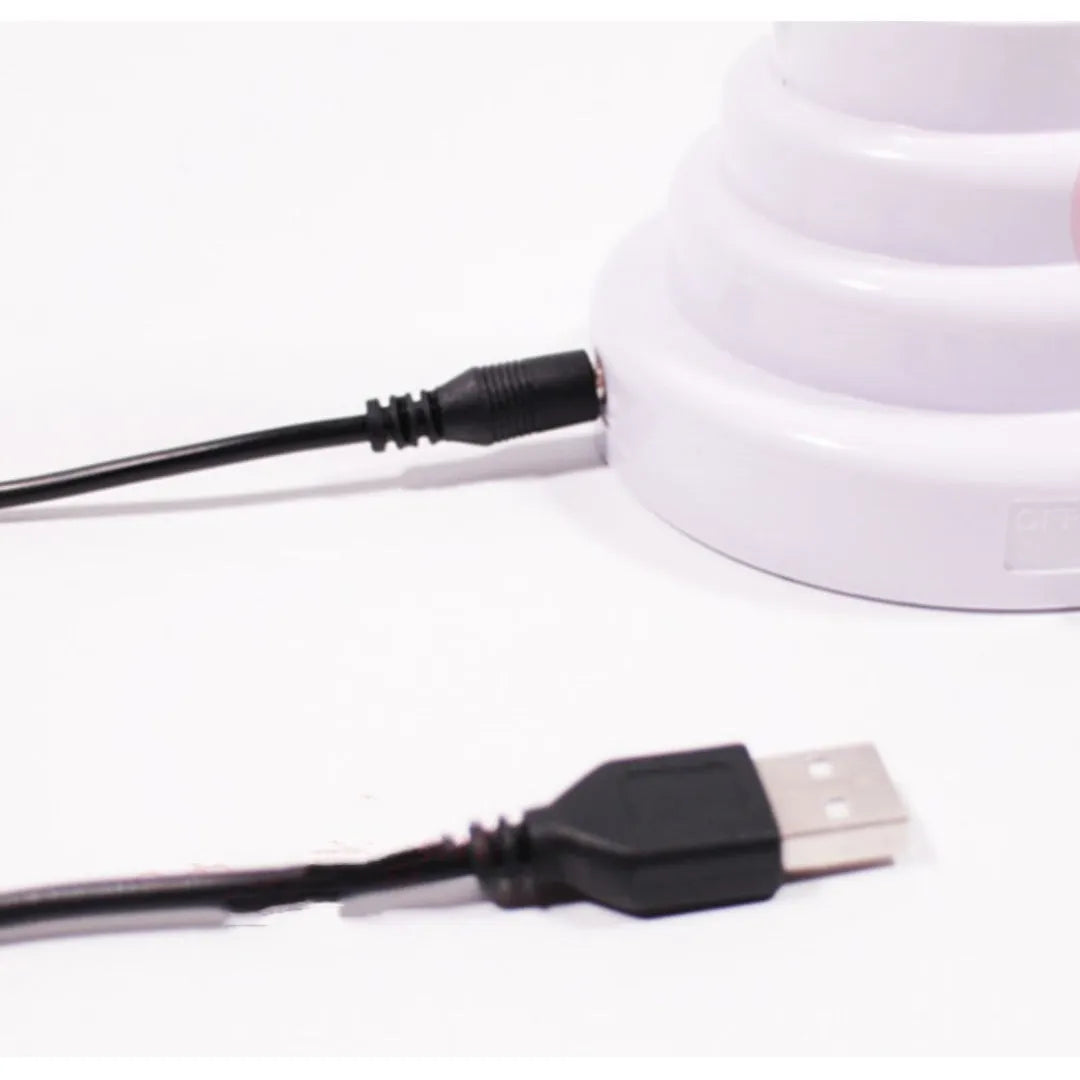 Minimalist white bamboo-shaped desk lamp emitting a soft green LED light, with a black USB cable.