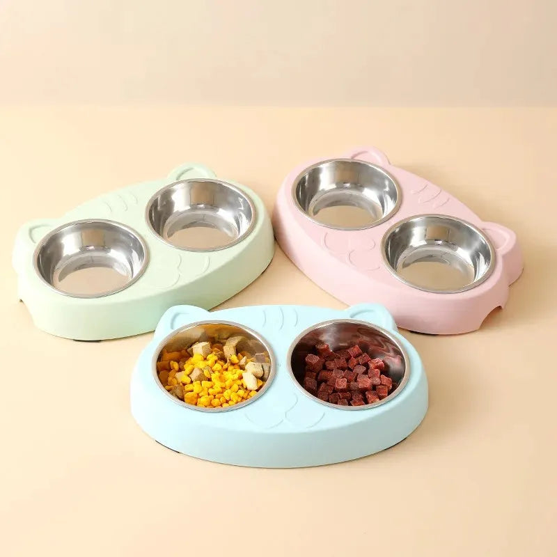 Blue plastic double bowl pet feeding tray for cats and dogs with non-slip rubber feet on a floor.