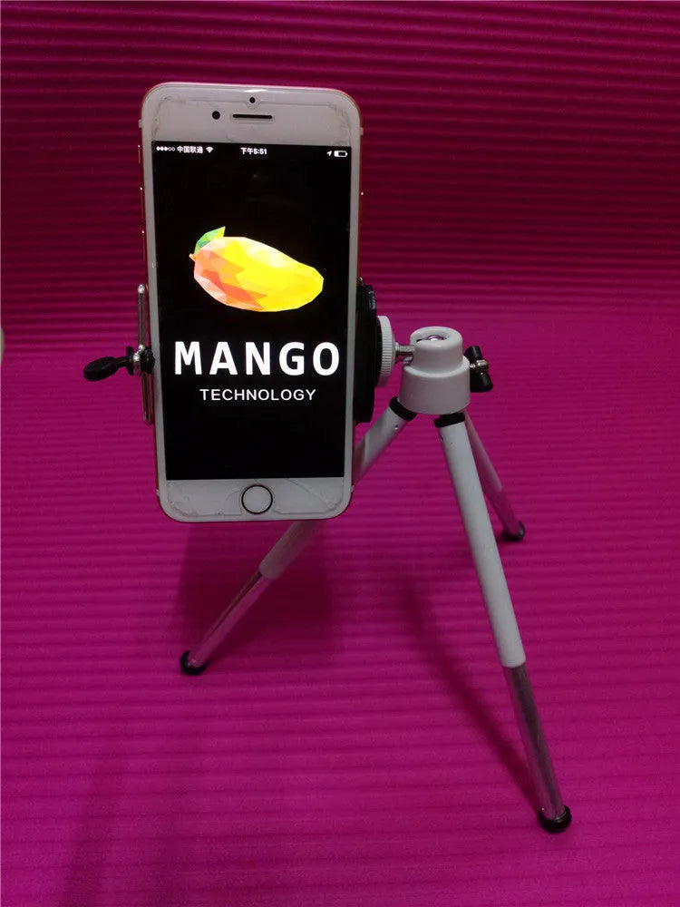 Black metal desktop phone holder with adjustable arm holding a smartphone on a wooden desk.