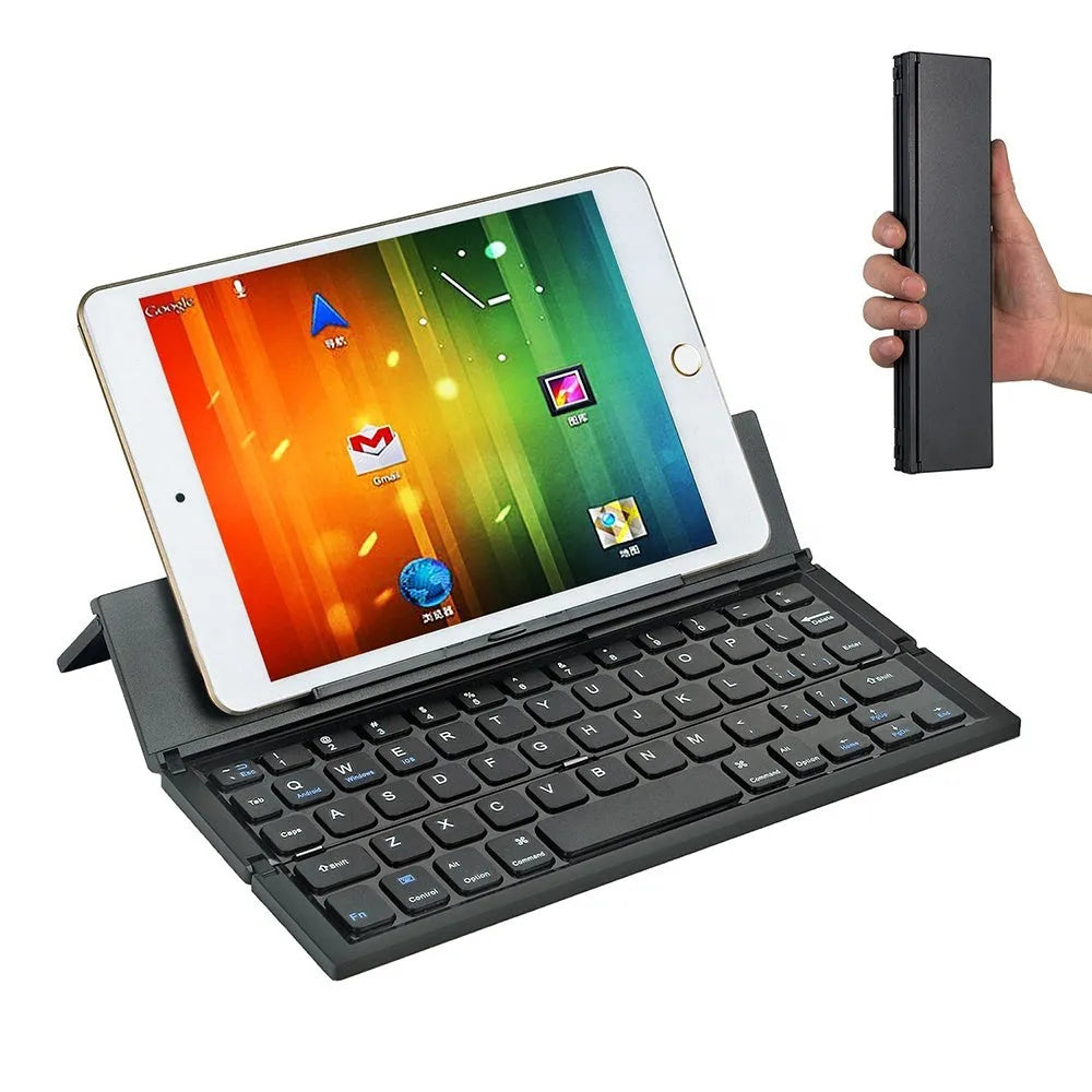 Black folding wireless Bluetooth keyboard unfolded next to tablet showing mini keyboard size