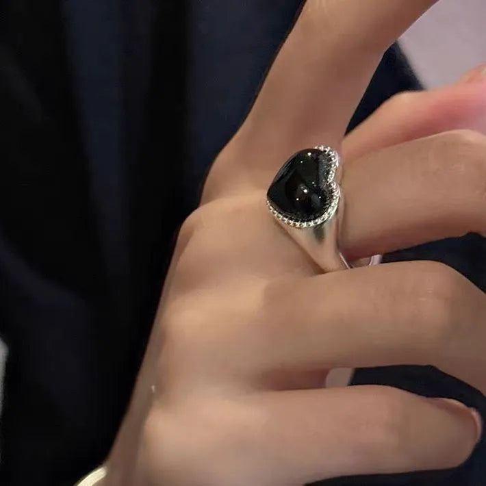 Adjustable open mouth sterling silver ring with a black agate heart on a silver band.