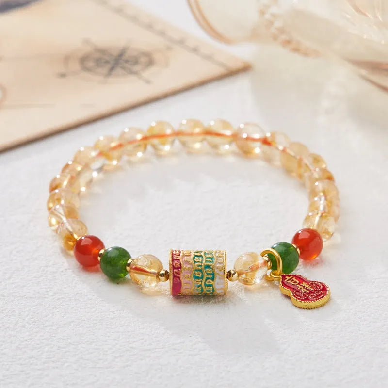 Hand-woven citrine five sutra bracelet with 6mm geometric beads on a wrist.