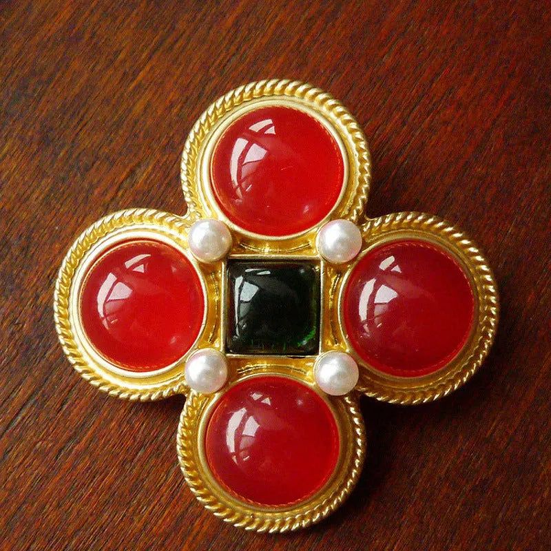 A vintage-style baroque brooch made of zinc alloy in a diamond shape on a fabric background.