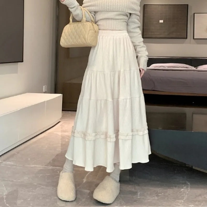Women's milky white corduroy A-line midi skirt with an elastic waistband on a hanger.
