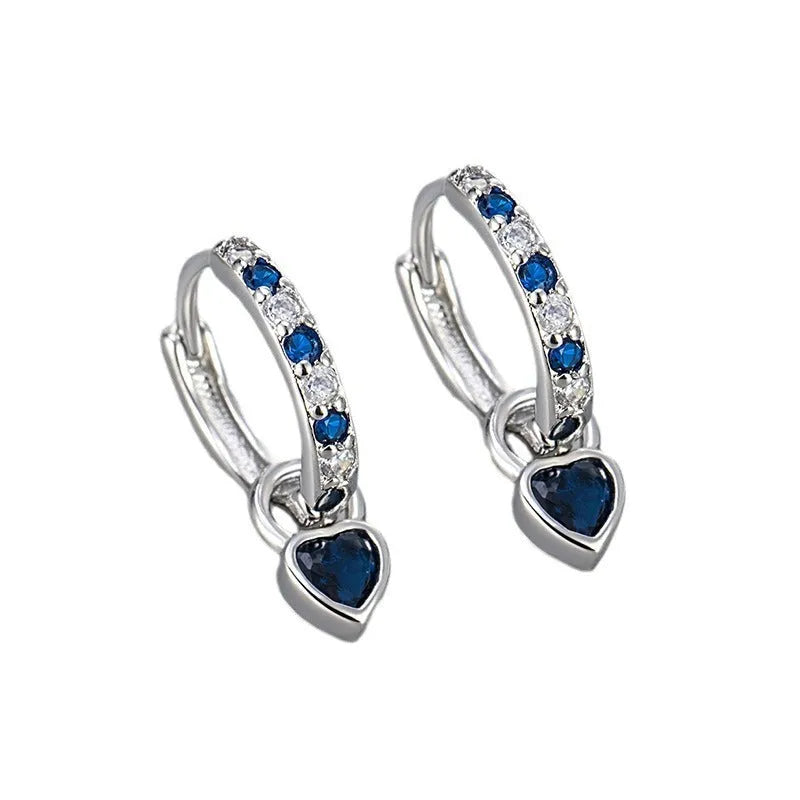 Women's fashion earrings with heart-shaped drops containing coloured gemstones in gold or white gold colour settings