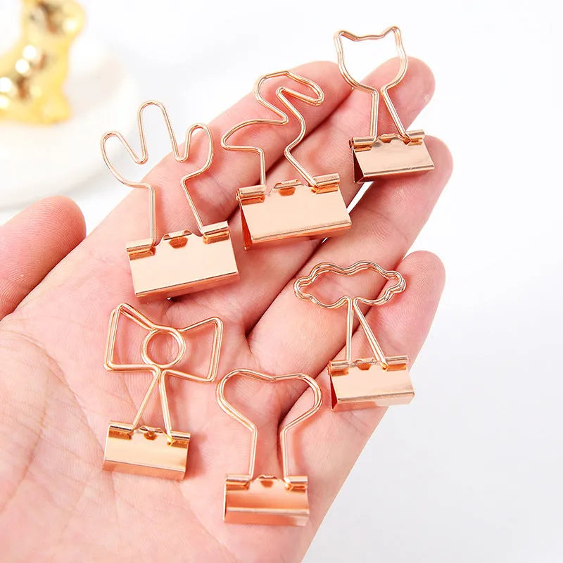 Gold-plated long tail metal paper clip showing decorative flamingo, love, clouds, cat, cactus, and bow design options.