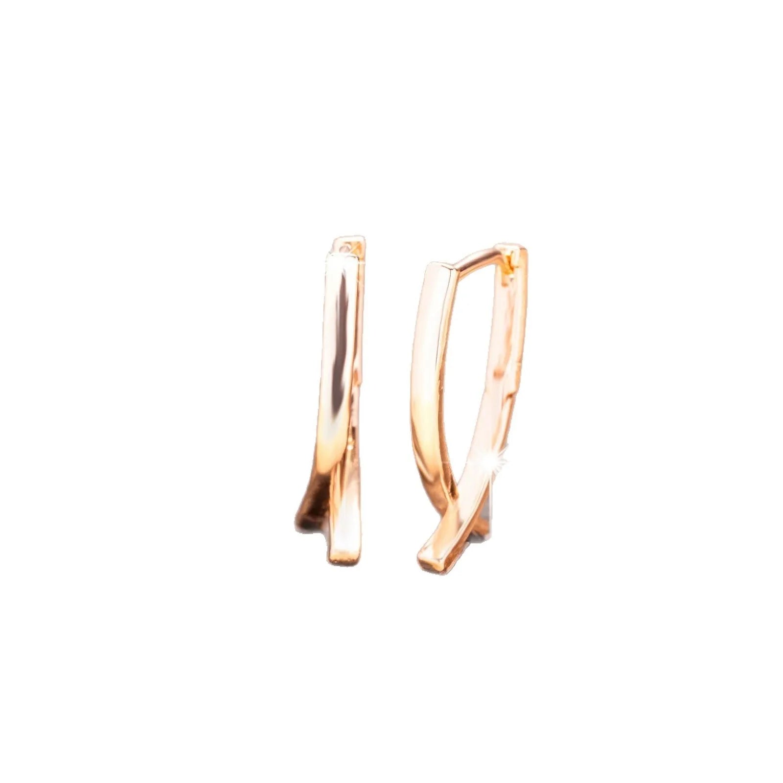 A pair of rose gold cross-shaped earrings made from copper on a white background.